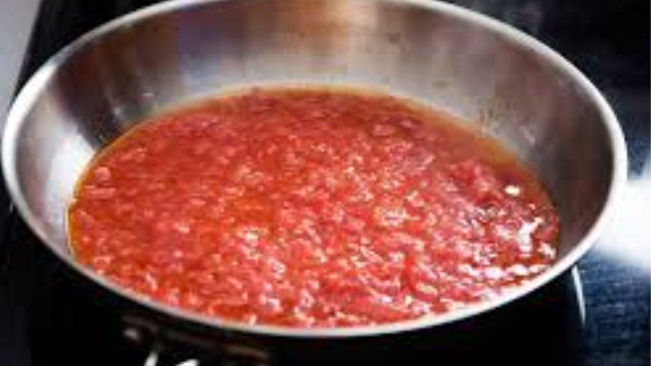 Garlic cooking in a pan with tomato ketchup, soy sauce, and chili sauce