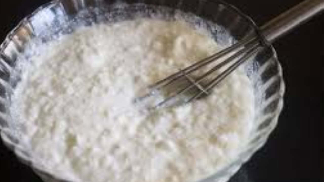 Mixing raw mango, onions, and curd in a bowl