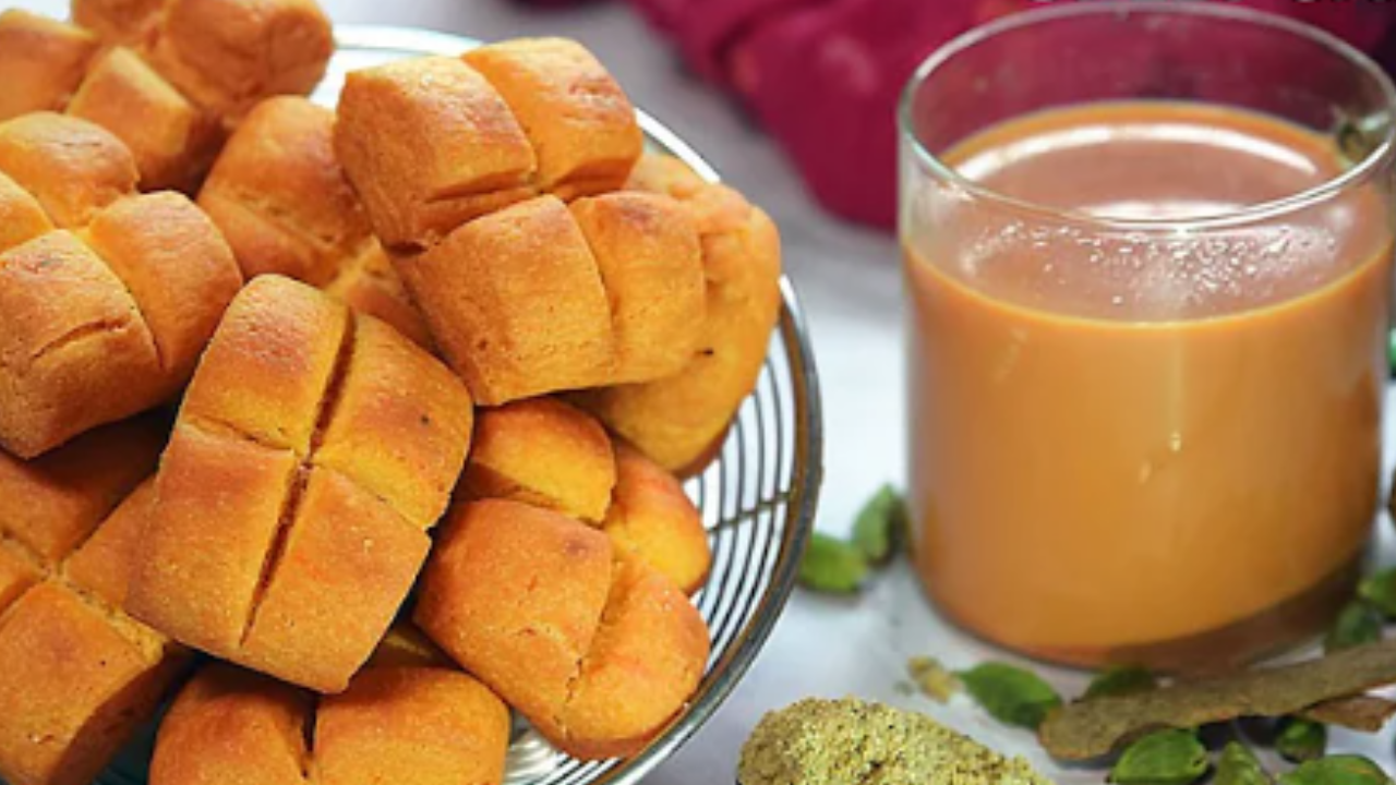 A plate of freshly made crispy spread cakes served alongside a cup of hot tea